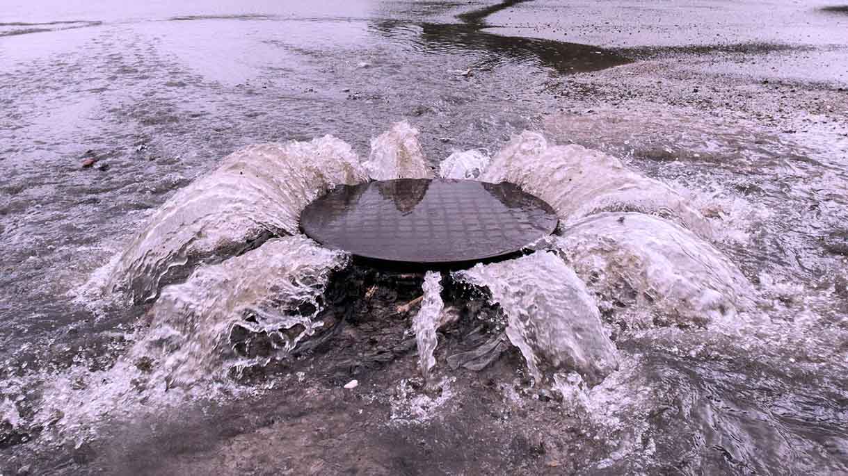 Abwasser tritt während eines Rückstaus aus dem Kanal aus