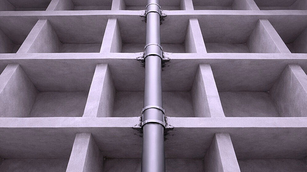 Schematische Darstellung eines Rohres, dass durch mehrere Geschossdecken nach oben geführt wird.