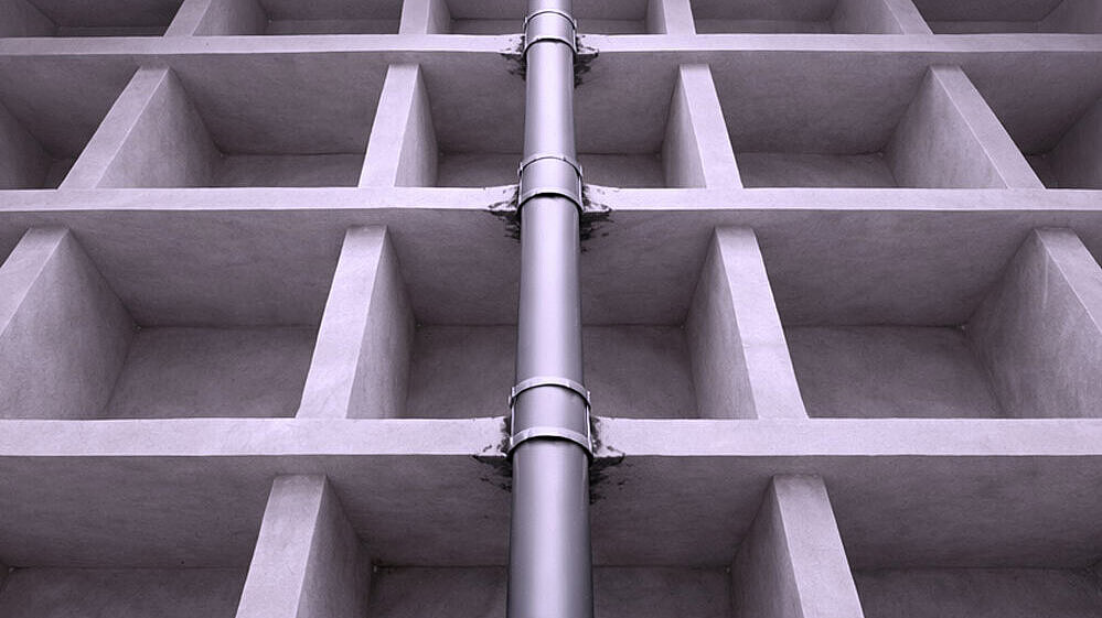 Schematische Darstellung eines Rohres, dass durch mehrere Geschossdecken nach oben geführt wird.